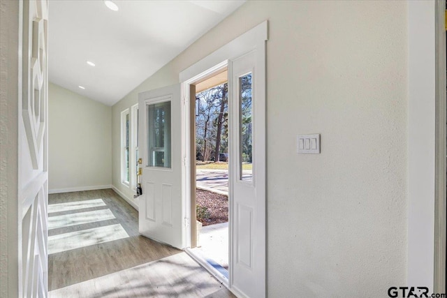 foyer with lofted ceiling and light hardwood / wood-style flooring