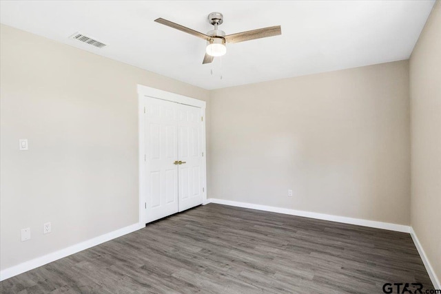 empty room featuring ceiling fan and dark wood-type flooring