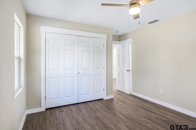 unfurnished bedroom featuring wood-type flooring, a closet, and ceiling fan