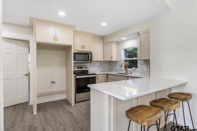 kitchen with stainless steel appliances, tasteful backsplash, a breakfast bar area, and sink