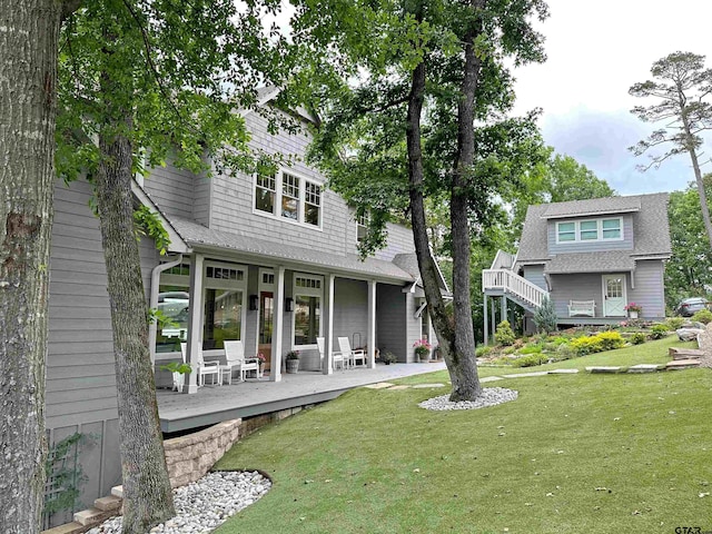 rear view of property featuring a lawn