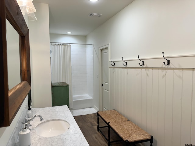 bathroom with vanity, wood finished floors, visible vents, and shower / bathtub combination with curtain