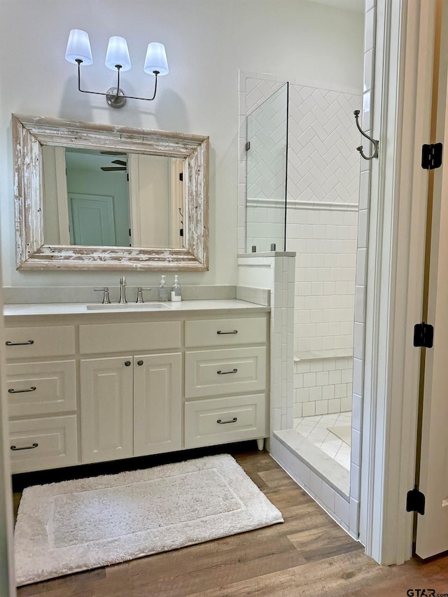 full bathroom featuring a walk in shower, wood finished floors, and vanity