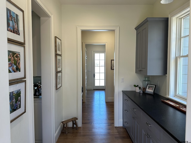 hall with dark wood-style floors and baseboards