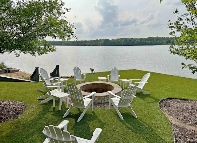 exterior space with an outdoor fire pit and a water view