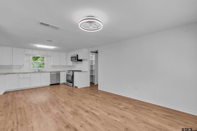 kitchen featuring visible vents, light wood-type flooring, a sink, stainless steel appliances, and white cabinetry