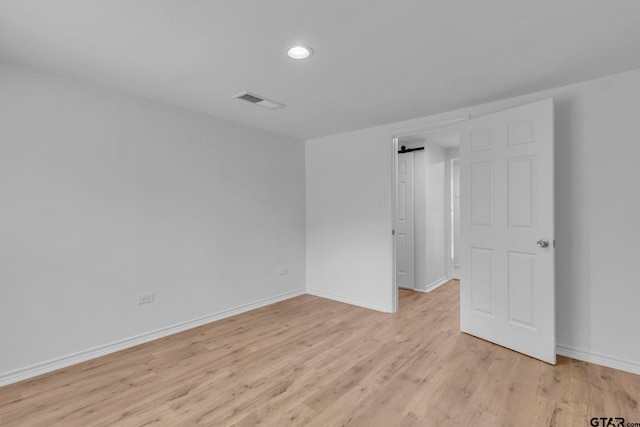 spare room with baseboards, light wood-type flooring, recessed lighting, and visible vents