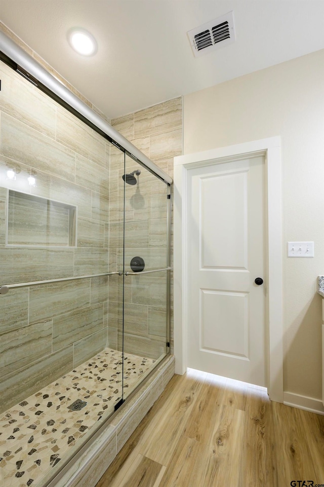 bathroom featuring walk in shower and wood-type flooring