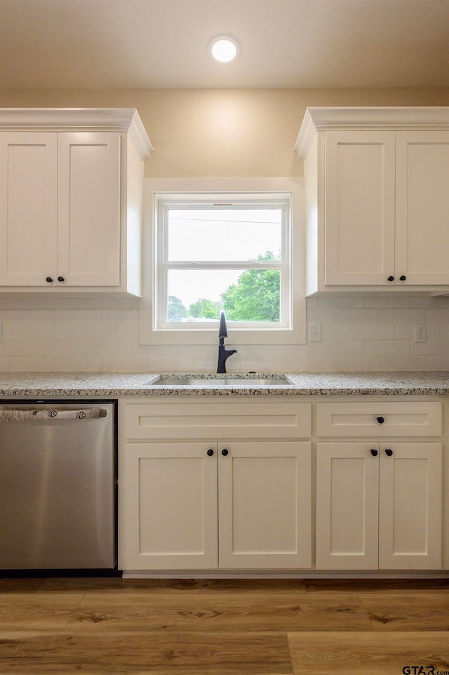 kitchen featuring backsplash, sink, light hardwood / wood-style flooring, and dishwasher