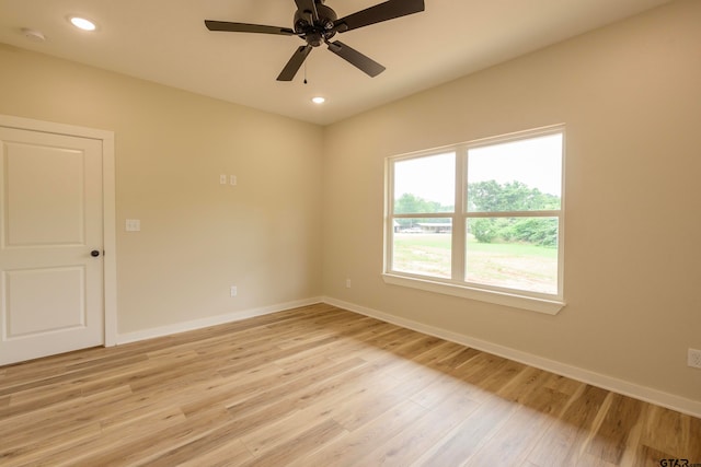 empty room with ceiling fan and light hardwood / wood-style flooring