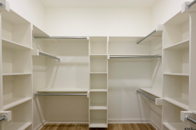 walk in closet with hardwood / wood-style flooring