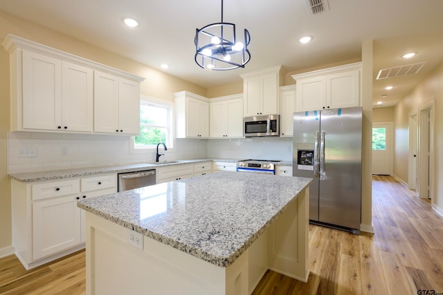 kitchen with white cabinetry, a center island, and stainless steel appliances