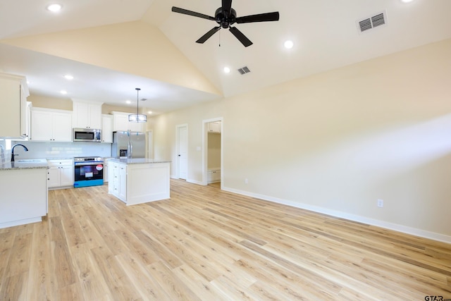 kitchen with light hardwood / wood-style flooring, hanging light fixtures, a kitchen island, white cabinetry, and appliances with stainless steel finishes