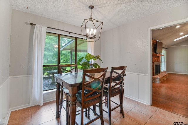 201 Karla Dr, Whitehouse, TX 75791 - dining room featuring plenty of natural light, a textured ceiling, a chandelier, light tile patterned floors, and wainscoting