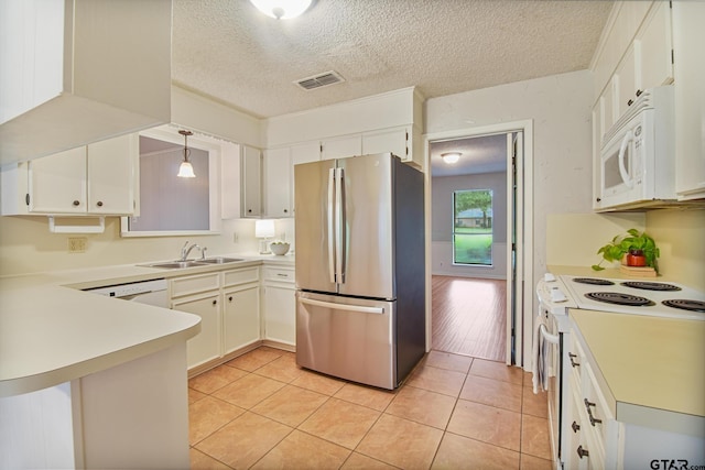 201 Karla Dr, Whitehouse, TX 75791 - kitchen with white appliances, a textured ceiling, a peninsula, light countertops, and light tile patterned floors