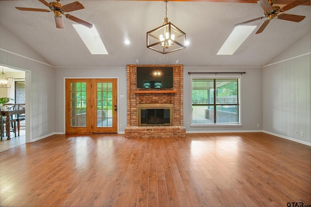 201 Karla Dr, Whitehouse, TX 75791 - unfurnished living room featuring a skylight, vaulted ceiling, a chandelier, wood finished floors, and healthy amount of natural light