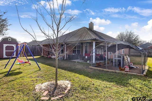 back of property featuring a yard, a fenced backyard, brick siding, and an outdoor structure