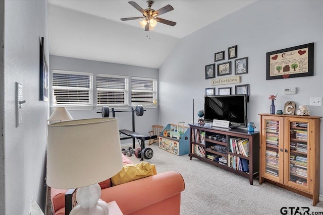 carpeted living area with a ceiling fan and vaulted ceiling