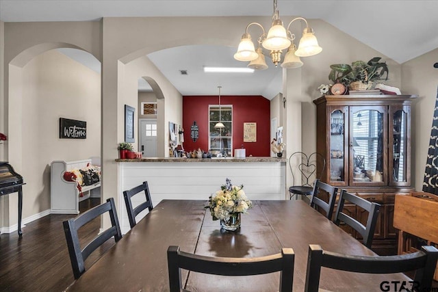 dining area featuring baseboards, lofted ceiling, visible vents, and wood finished floors