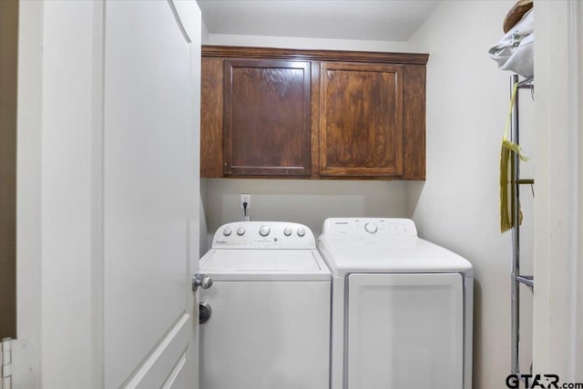 clothes washing area with cabinet space and washing machine and dryer