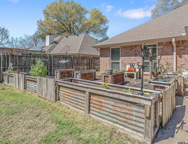 21105 Altuda Ln, Flint, TX 75762 - rear view of house featuring a garden, brick siding, and a shingled roof