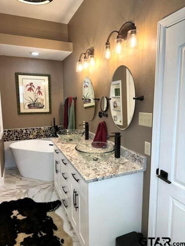 21105 Altuda Ln, Flint, TX 75762 - bathroom with double vanity, a freestanding tub, and marble finish flooring
