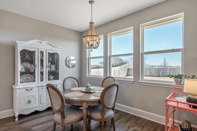 dining room with dark wood-style flooring, baseboards, and an inviting chandelier