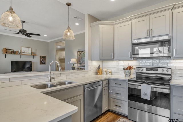 kitchen with tasteful backsplash, stainless steel appliances, a sink, and gray cabinetry