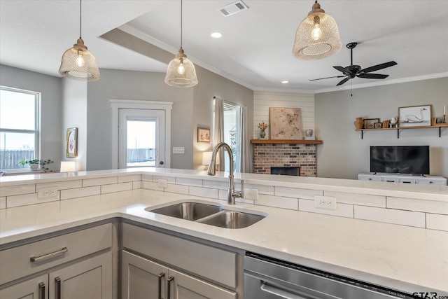 kitchen with a sink, visible vents, a healthy amount of sunlight, open floor plan, and stainless steel dishwasher