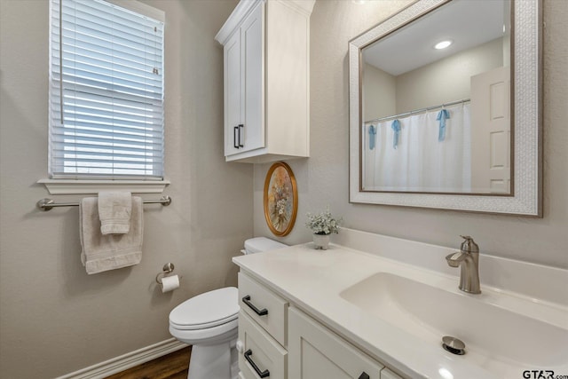 full bathroom with toilet, a shower with shower curtain, wood finished floors, vanity, and baseboards