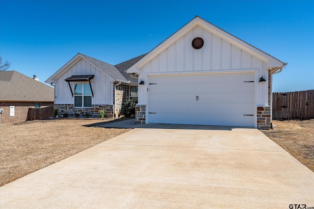 view of front of home featuring board and batten siding, stone siding, an attached garage, and concrete driveway