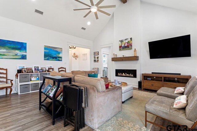 911 Charlie, Whitehouse, TX 75791 - living area featuring a ceiling fan, high vaulted ceiling, wood finished floors, a warm lit fireplace, and beam ceiling