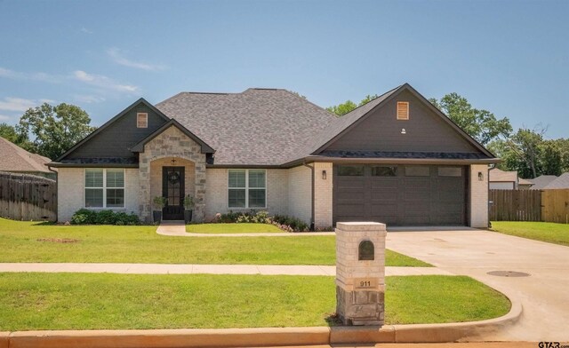911 Charlie, Whitehouse, TX 75791 - view of front of house featuring a garage, driveway, brick siding, roof with shingles, and stone siding