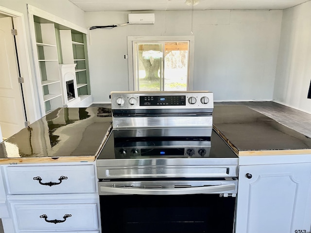 kitchen featuring electric range, white cabinets, and a wall mounted air conditioner