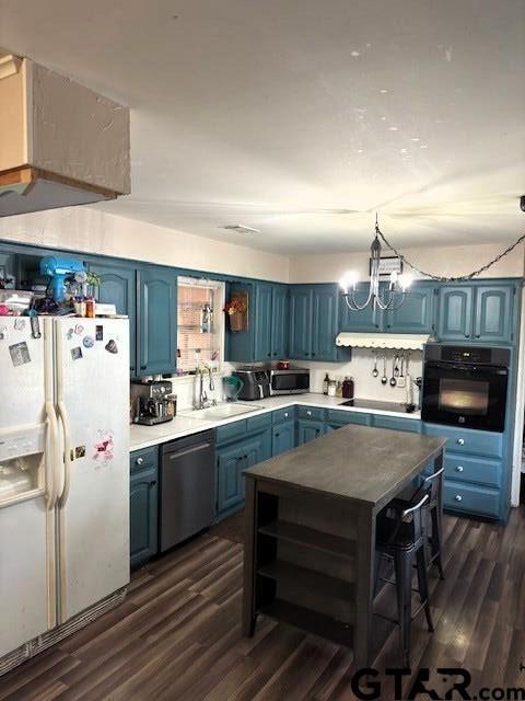 kitchen with black appliances, blue cabinetry, open shelves, a sink, and dark wood-style flooring