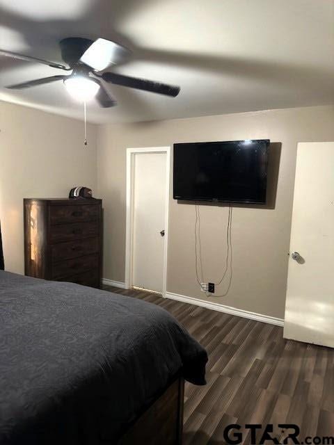 bedroom with a ceiling fan, dark wood-style flooring, and baseboards