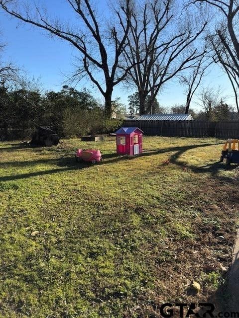 view of yard with an outdoor structure and fence