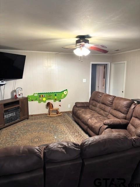 living room featuring a ceiling fan and ornamental molding