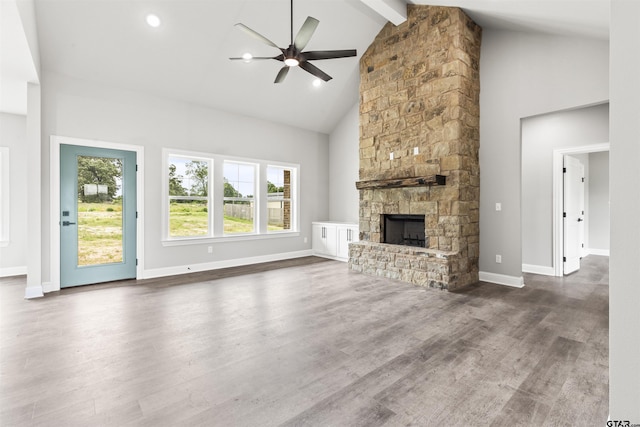 unfurnished living room with high vaulted ceiling, ceiling fan, a fireplace, beamed ceiling, and dark hardwood / wood-style flooring