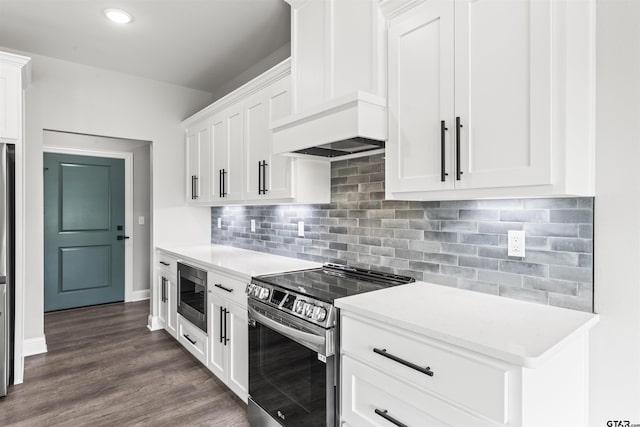 kitchen featuring appliances with stainless steel finishes, tasteful backsplash, premium range hood, dark hardwood / wood-style floors, and white cabinetry