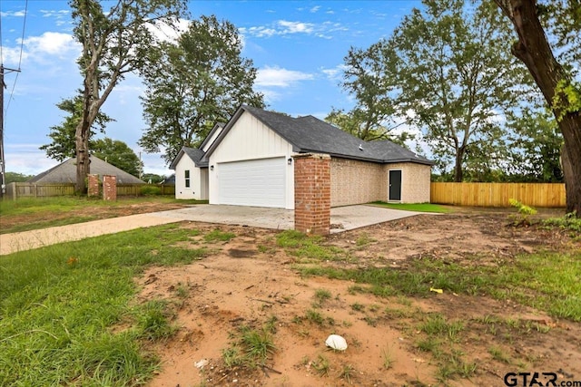 1002 E Main St, Whitehouse, TX 75791 - view of side of property featuring a garage, concrete driveway, and brick siding