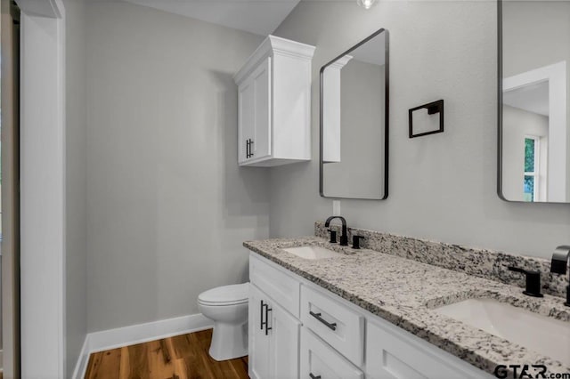 1002 E Main St, Whitehouse, TX 75791 - bathroom featuring toilet, baseboards, double vanity, and wood finished floors