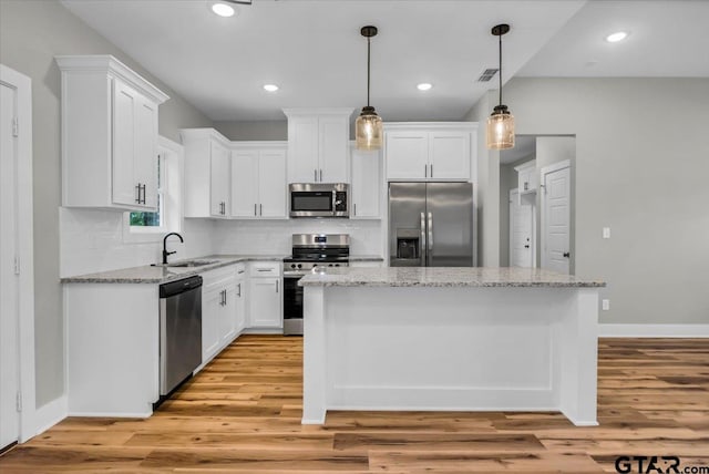 1002 E Main St, Whitehouse, TX 75791 - kitchen with appliances with stainless steel finishes, white cabinets, light wood-style floors, a center island, and recessed lighting