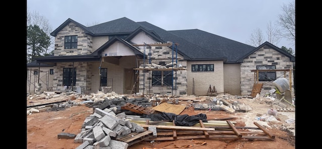 exterior space with stone siding, a shingled roof, and brick siding