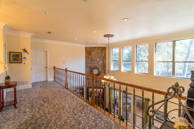 corridor featuring an inviting chandelier, carpet, and ornamental molding