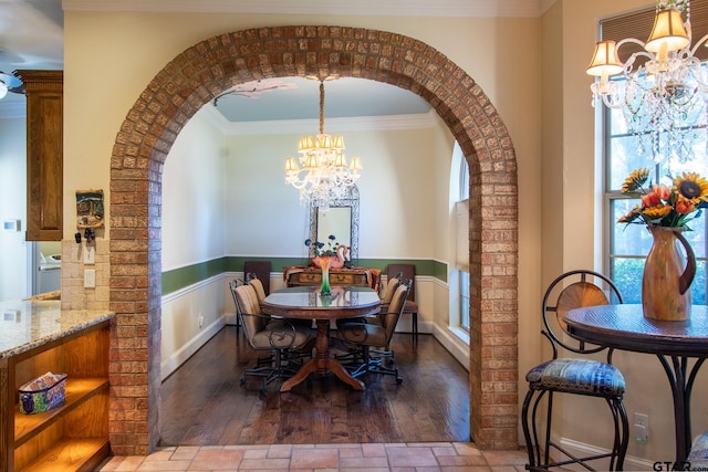 dining area featuring hardwood / wood-style floors, a chandelier, and crown molding