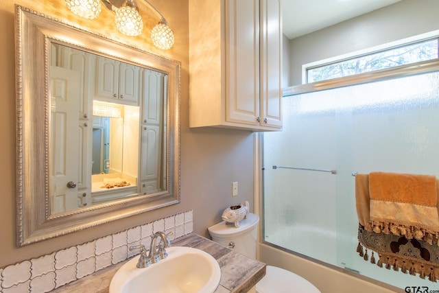 full bathroom featuring enclosed tub / shower combo, vanity, and toilet