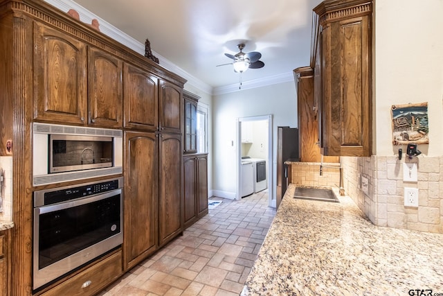 kitchen featuring stainless steel appliances, tasteful backsplash, light stone countertops, ceiling fan, and crown molding