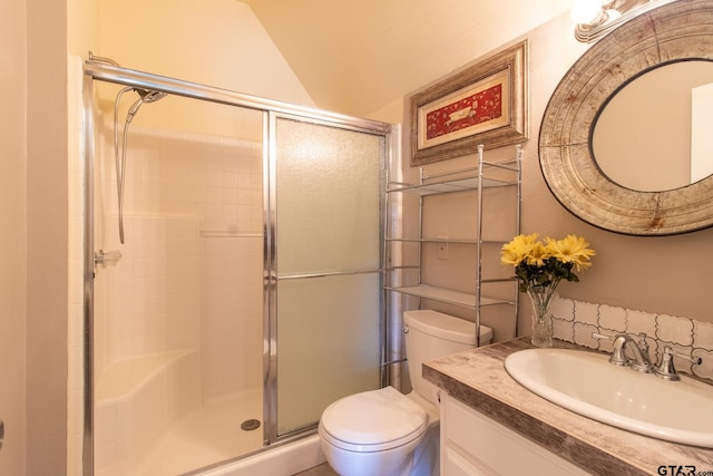 bathroom with toilet, vanity, lofted ceiling, and a shower with shower door