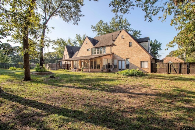 rear view of house featuring a lawn